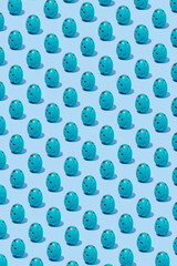 Pattern of  blue shiny Easter egg casting shadow on blue background, minimalism concept