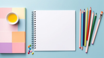 a clean empty sheet of paper surrounded by paints, pencils, stationery, layout, canvas, blank, table, drawing, picture, notepad, colored, bright, notebook, sketchbook