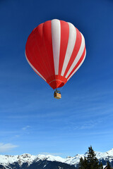 Fototapeta na wymiar Red Hot air balloon on the slopes of Courchevel ski resort by winter