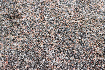 Crushed stone, close-up with selective focus. Fine granite crushed stone. Construction materials, background. Gravel