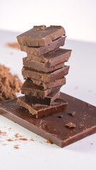 Cocoa Powder Chocolate Bar Coins. Chunks of chocolate, money on white background concept of rising cocoa prices, world chocolate prices are rising due to the poor harvest of cocoa. Rising chocolate