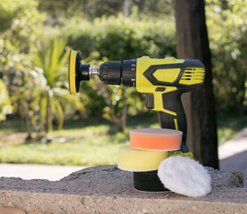 A black and yellow glass sander polisher along with different replaceable sponges.