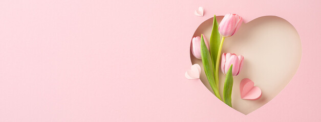 Chic Mother's Day vision: Top-view shot of tulips, and paper hearts within a heart-shaped frame against pastel pink. Ideal for messages or promotions