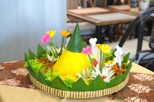 Tumpeng or nasi tumpeng is a Javanese food in which yellow rice , served in a cone shape and arranged together with the side dishes