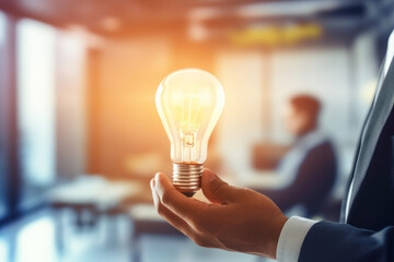 An entrepreneur holding a glowing light bulb, symbolizing innovation and business success. - 781343792