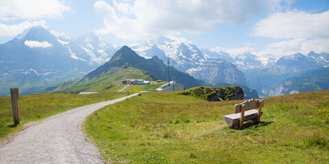 pictorial hiking route Mannlichen mountain, with bench and alps view, switzerland - 781344132