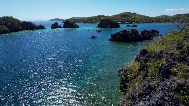 4K Aerial drone video of Siete Pecados Siete with boats surrounded by blue sea. Coron, Palawan. Philippines.