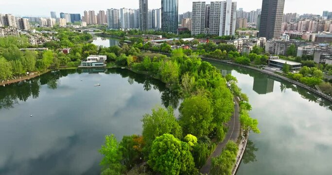 Aerial Cityscape of Chengdu at spring day in the Donghu park with fresh green trees by the riverside woods.