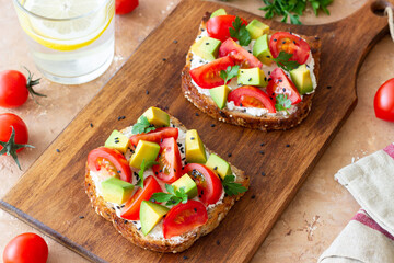 Toast with white cheese, tomatoes and avocado. Healthy eating. Vegetarian food.