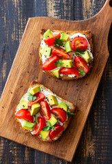 Toast with white cheese, tomatoes and avocado. Healthy eating. Vegetarian food.