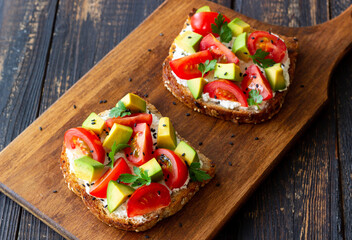Toast with white cheese, tomatoes and avocado. Healthy eating. Vegetarian food.