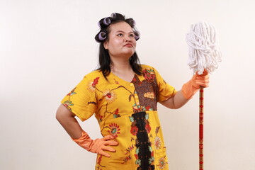 Asian housekeeper standing looking above while holding mop