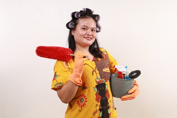 Happy smiling asian housekeeper woman standing while holding home cleaning equipment