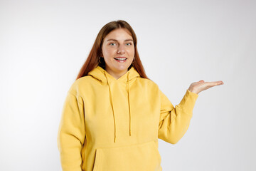 Pretty cheerful woman in casual clothes showing away isolated over white background, studio portrait. Human emotions, facial expression and symbols concept.