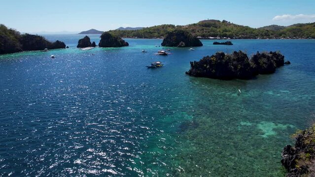 4K Aerial drone video of Siete Pecados Siete with boats surrounded by blue sea. Coron, Palawan. Philippines.