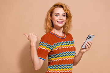 Photo of satisfied woman dressed ornament t-shirt hold smartphone indicating at offer empty space...