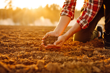 Farmer's hands holding soil, checking soil health before sowing. Ecology, agriculture concept.