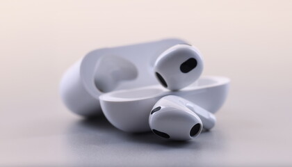 White electronic bluetooth headphones and technical cases on white background. Fashion stylish...