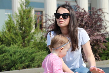 A small child in a pink jacket with his mother on a walk