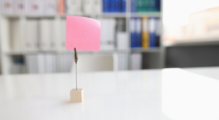 Office desk with pink sticker and paper clip. Business note with copy space