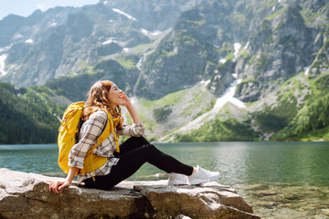 Happy woman feeling happy among amazing mountains, forest and lake, enjoy the nature landscape....