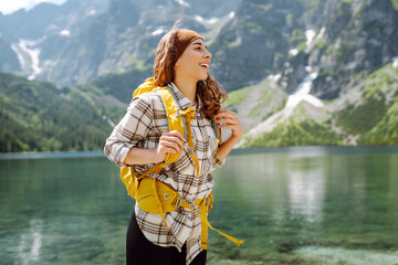 Happy woman feeling happy among amazing mountains, forest and lake, enjoy the nature landscape....