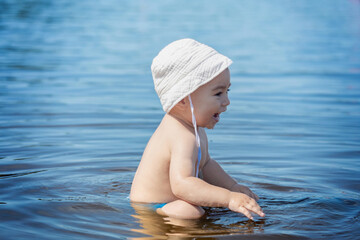 happy child in water on summer day, baby sunscreen for skin
