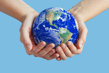 Person holds the Earth between their hands isolated on light blue background. Concept of responsibility and care for the planet, with space for text