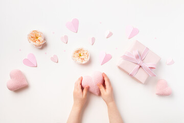 Child hands with gift or present box decorated with pink hearts and rose flowers for Happy mothers day. Holiday greting card.