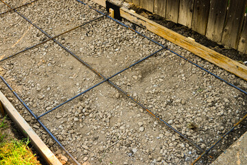 Wood forms in place with gravel and rebar and ready for concrete for new city sidewalk.