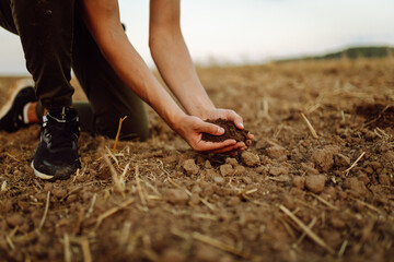Soil in the hands of the farmer woman. Fertile land. Ecology, agriculture concept.