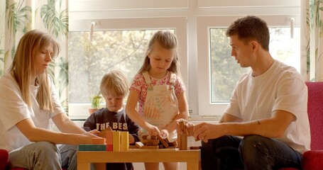 Family Bonding: The activity of playing with building blocks on the table showcases the strong bond...