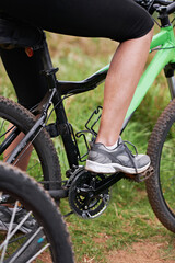 Person, legs and cyclist with bicycle in nature for paddling, cycling or outdoors sports in health...