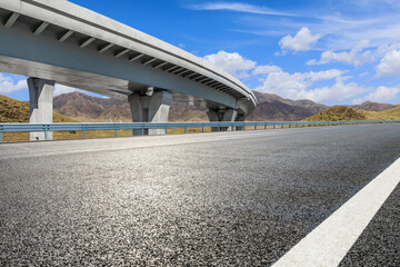 Asphalt highway road and viaduct with mountain nature background
