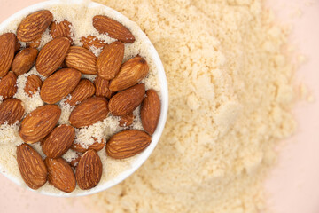 Almond flour and almonds on a beige background