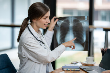 A doctor discusses chest X-ray results with her patient, explaining the health findings in a clear...