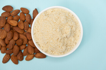 Almond flour and almonds on a blue background top view