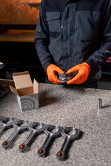 close up At the service station on the table young engine repairman prints out a new part for the...