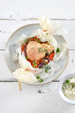 Tuna steak baked in a paper packet with vegetables