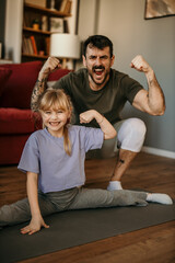 Fototapeta na wymiar Father and daughter engaged in homework together, clad in sporty attire, in a vibrant modern living room