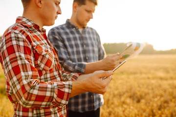 Two Farmers working with Tablet on wheat field. Smart farming and digital agriculture. 