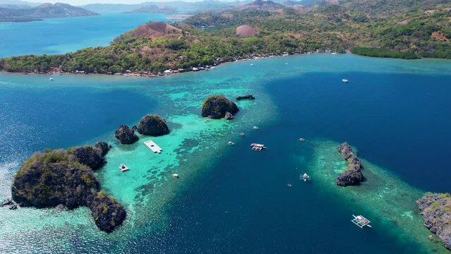 4K Aerial drone video of Siete Pecados Siete with boats surrounded by blue sea. Coron, Palawan. Philippines.