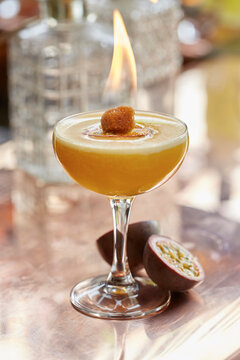 A passion fruit cocktail with flaming sugar cube