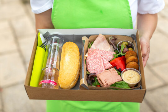 Lunch box with bread, falafel, hummus, sausage, pate and salad
