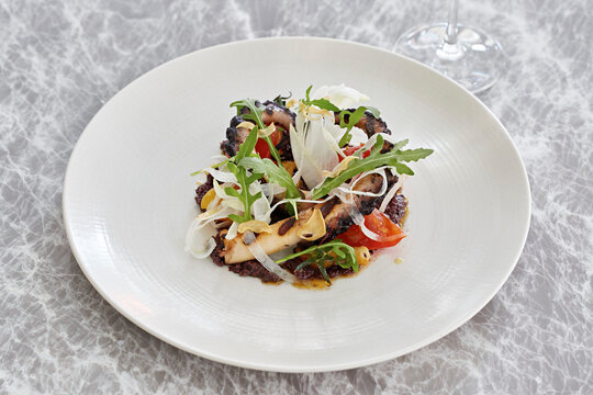 Octopus, fennel, tomato and rocket salad with fried garlic