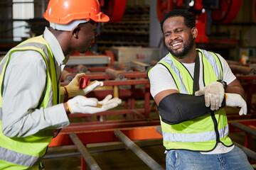 African factory worker or engineer wearing bandages splint. pain in elbow ache in arm from hard...