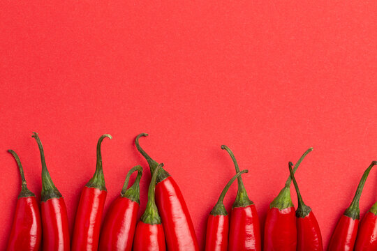 Red hot chilli peppers on minimal red background