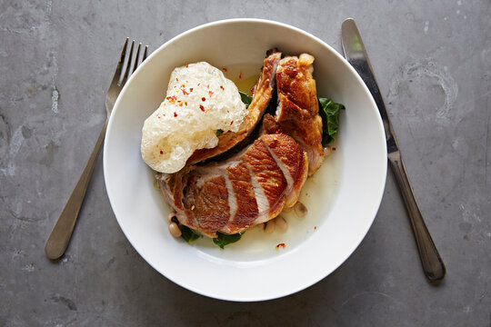 Pork chop, broth and crispy pigs skin