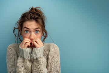 Femme anxieuse se rongeant les ongles sur un fond bleu, espace pour texte