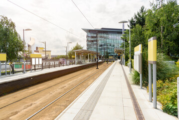 End of the line tram stop with platforms and blank billboards in a business district on a cloudy summer day